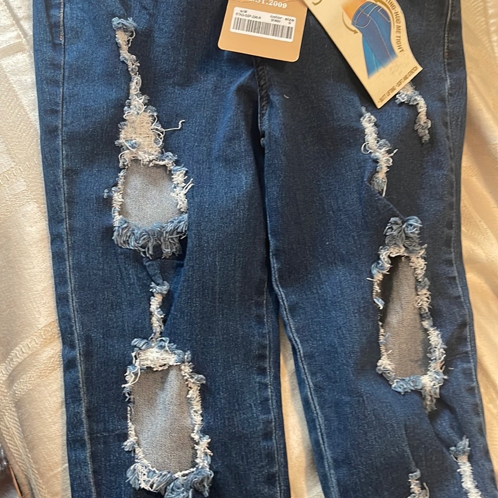 size 9 stag butt lifting jeans with ragged holes in front.  New blue jeans.